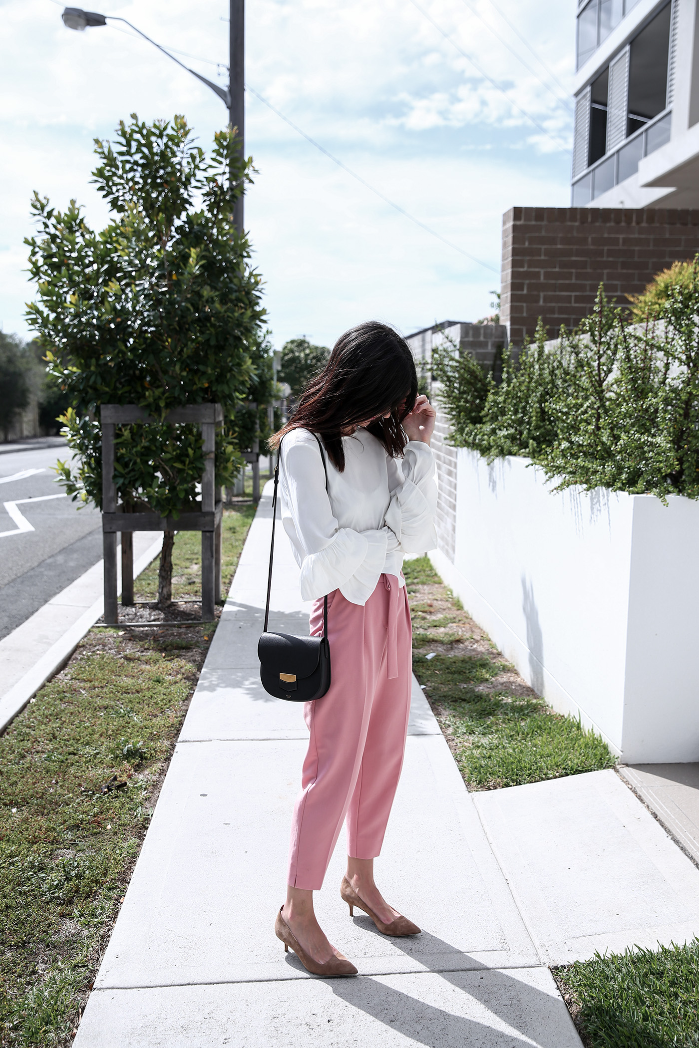 Outfit wearing pink trousers and a ruffle sleeve top