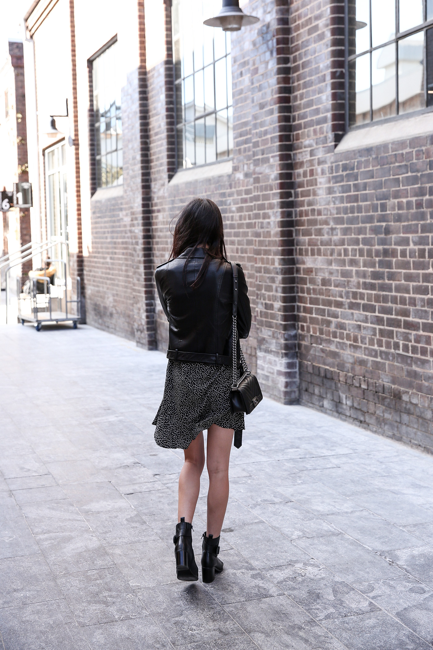 Minimal outfit wearing a polka dot dress and leather jacket