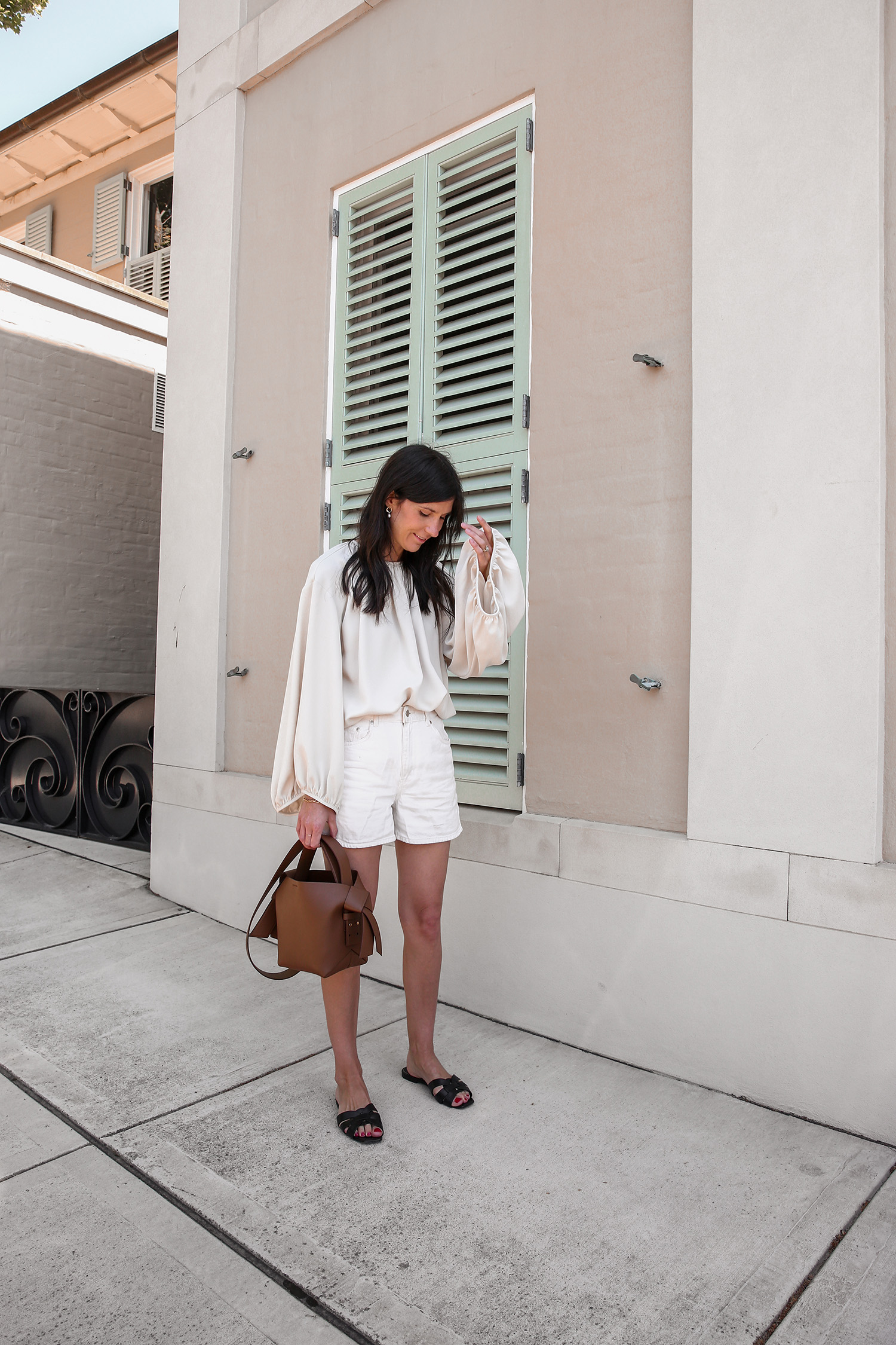 Minimalist neutral style outfit wearing Toteme top Arket shorts and Acne Mini Musubi bag in camel