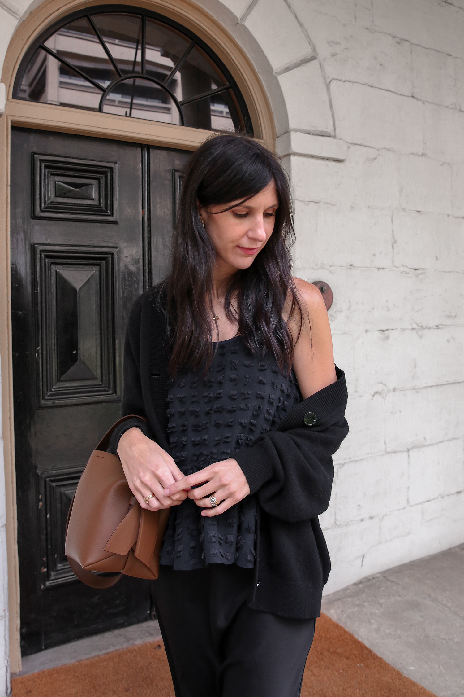 All black minimal outfit Tibi peplum top & Other Stories cardigan and Acne Studios musubi bag in camel