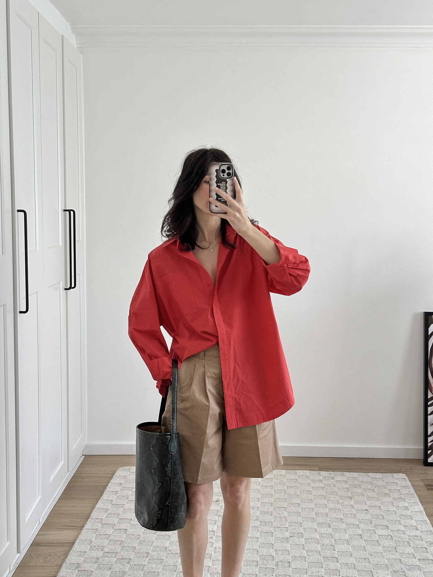 Styling a red shirt with beige Bermuda shorts and J.Crew Berkeley bucket tote